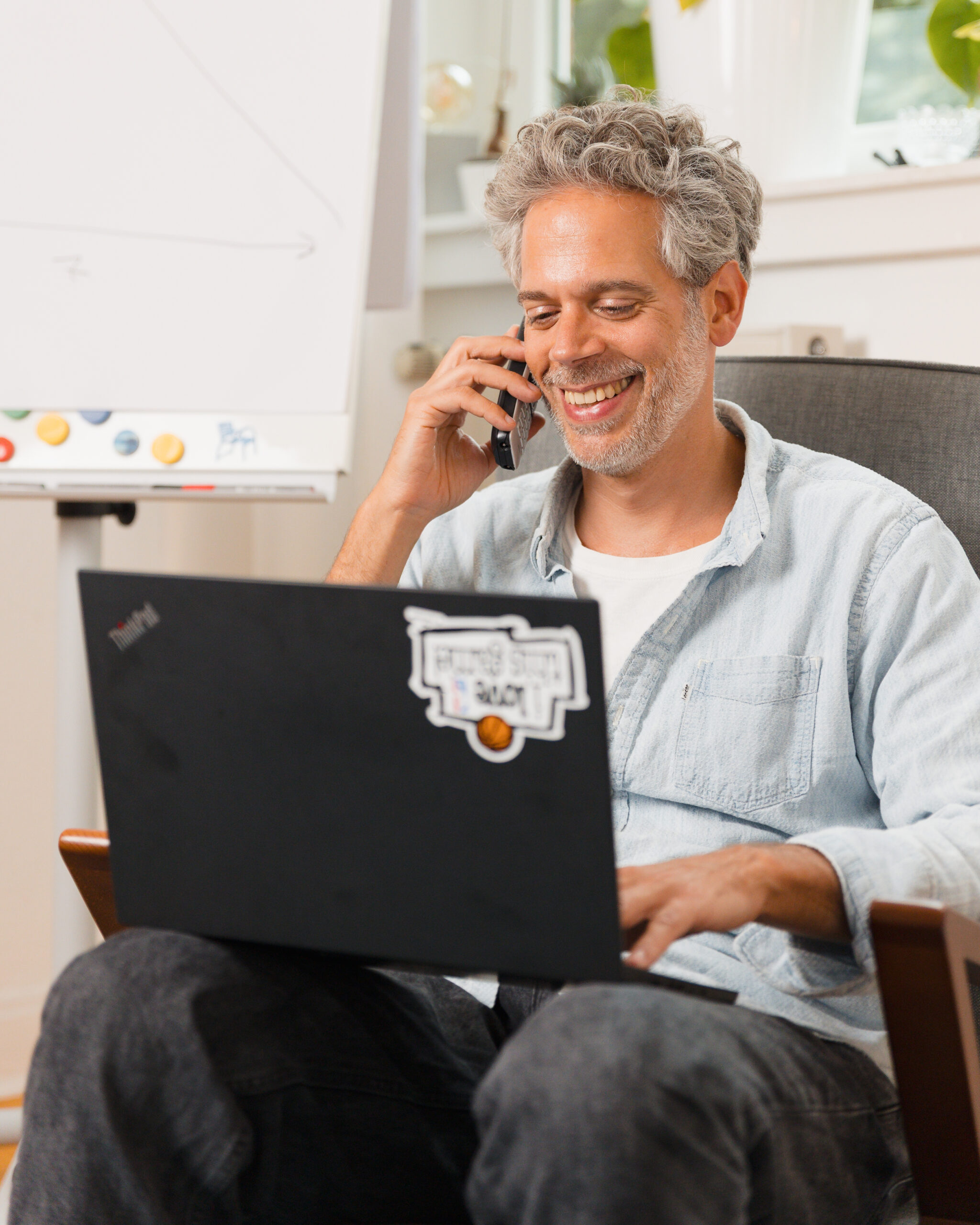 Dr. Luckey am Telefonieren mit Laptop auf dem Schoß